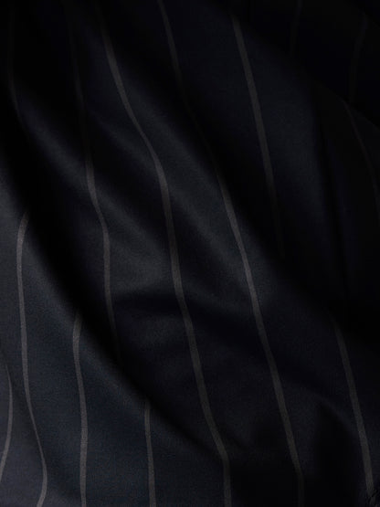 Close-up of the dark navy fabric with subtle vertical stripes from the Paul Smith x Castore T-shirt.