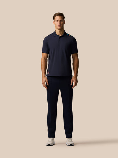 Front view of navy Paul Smith Castore ECB Ashes polo on a male model with colorful shoulder stripe