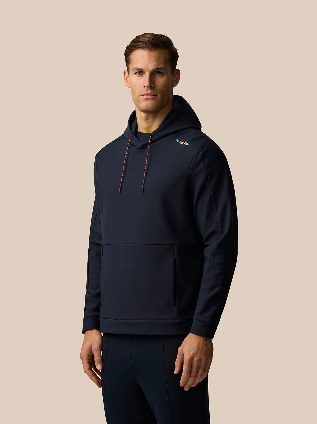 Profile view of a man in a navy England cricket hoodie showing the hood and relaxed fit.