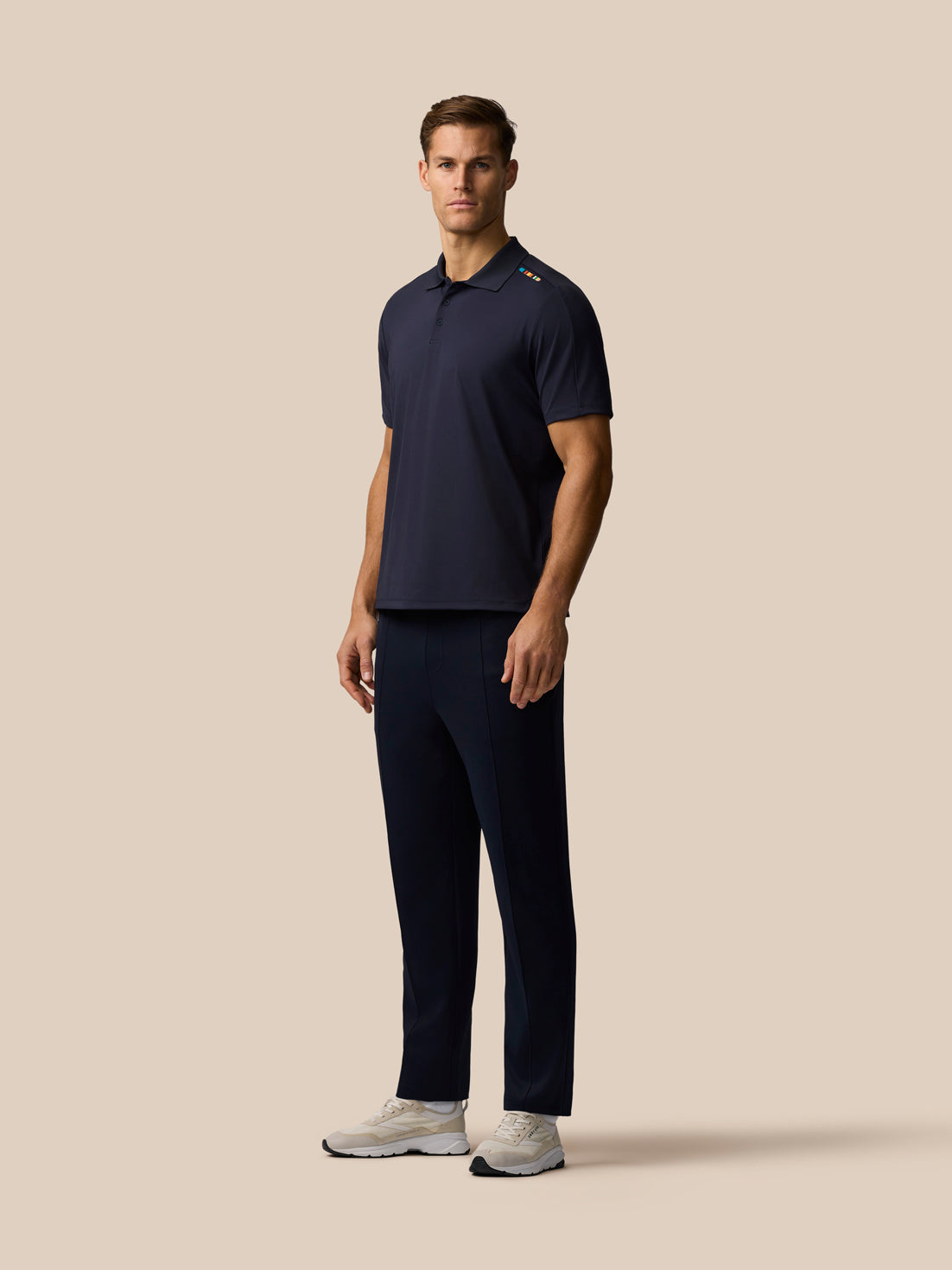 Side view of navy Paul Smith x Castore England Cricket unisex trousers with a multicolor knit stripe at the lower leg