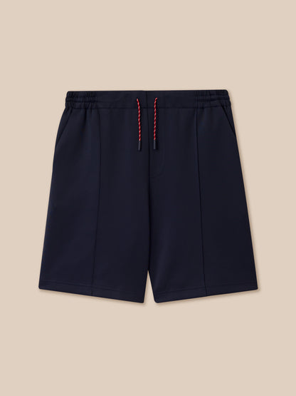 Close-up of navy shorts waist showing flat front waistband with elastic at back and three colored knit drawcords
