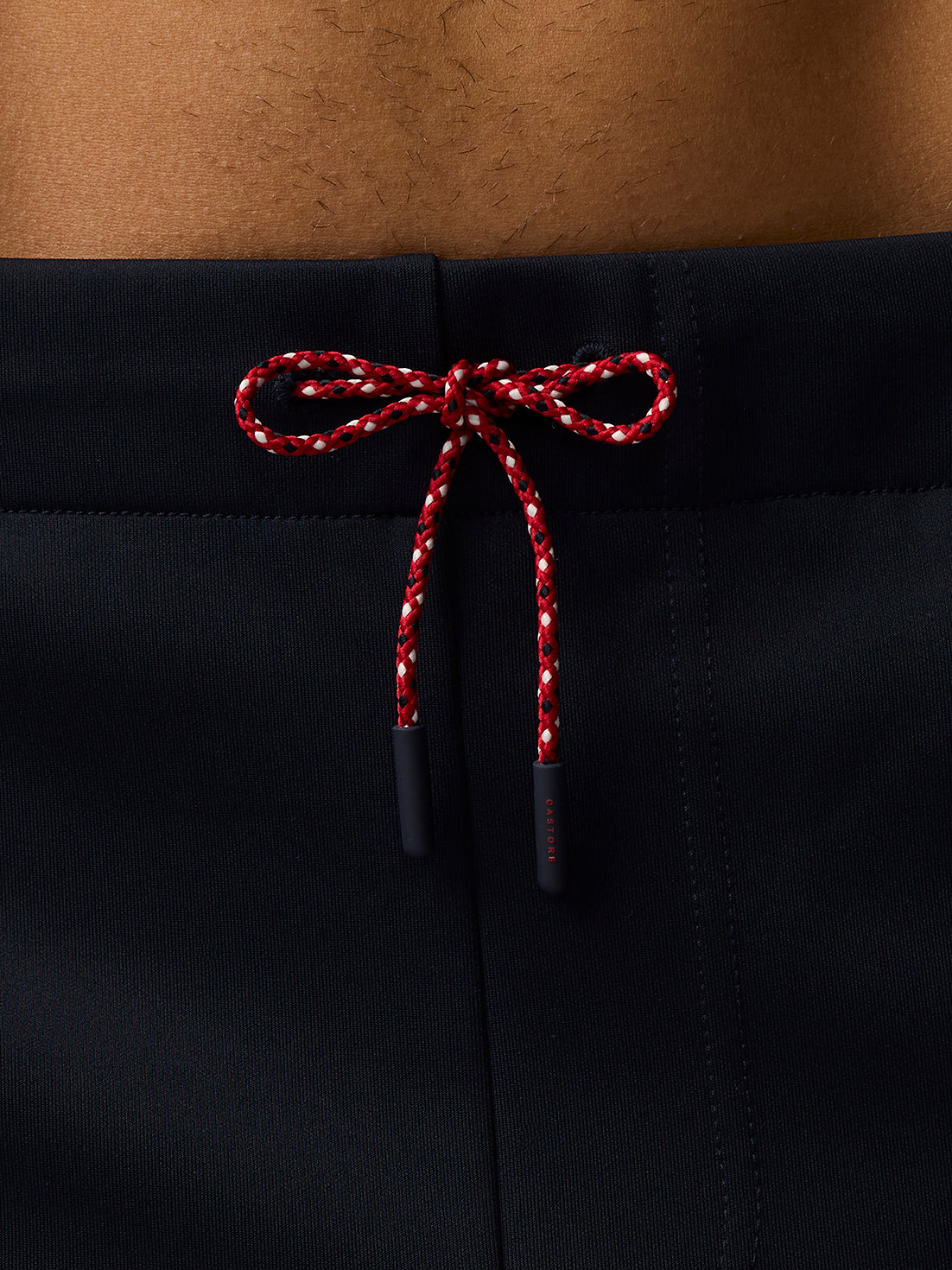 Close up of red and white drawstring tied in a bow at the navy shorts waistband.