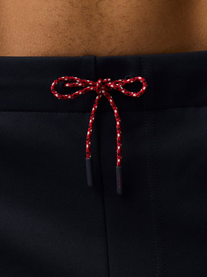 Close up of red and white drawstring tied in a bow at the navy shorts waistband.
