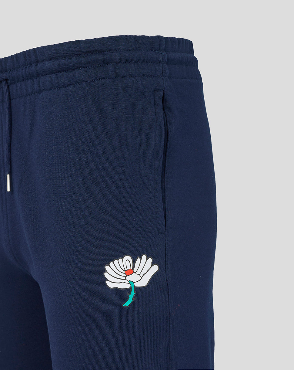 Navy blue sweatpants with a white embroidered flower design on a light gray background