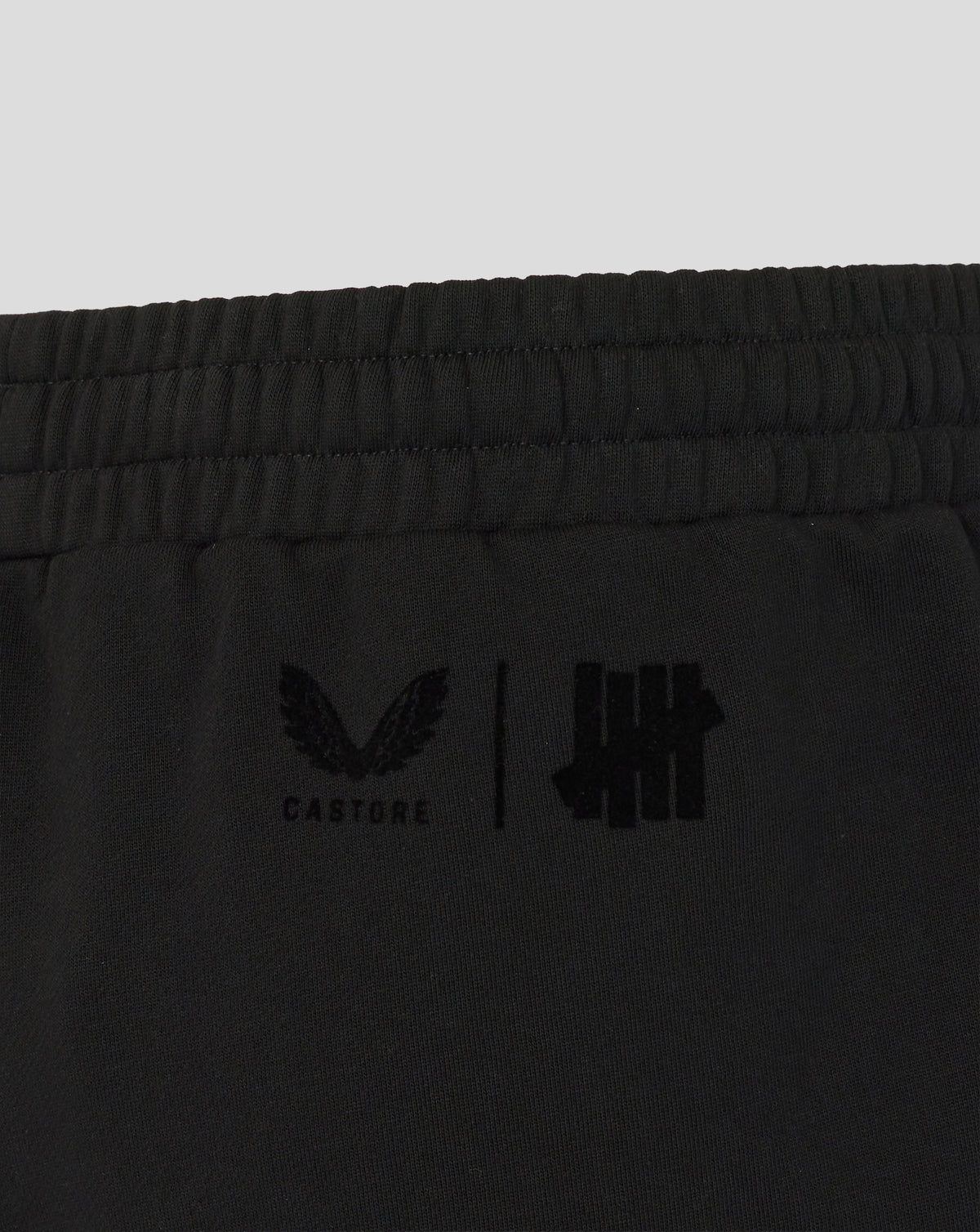 Black shorts with logos on a light gray background