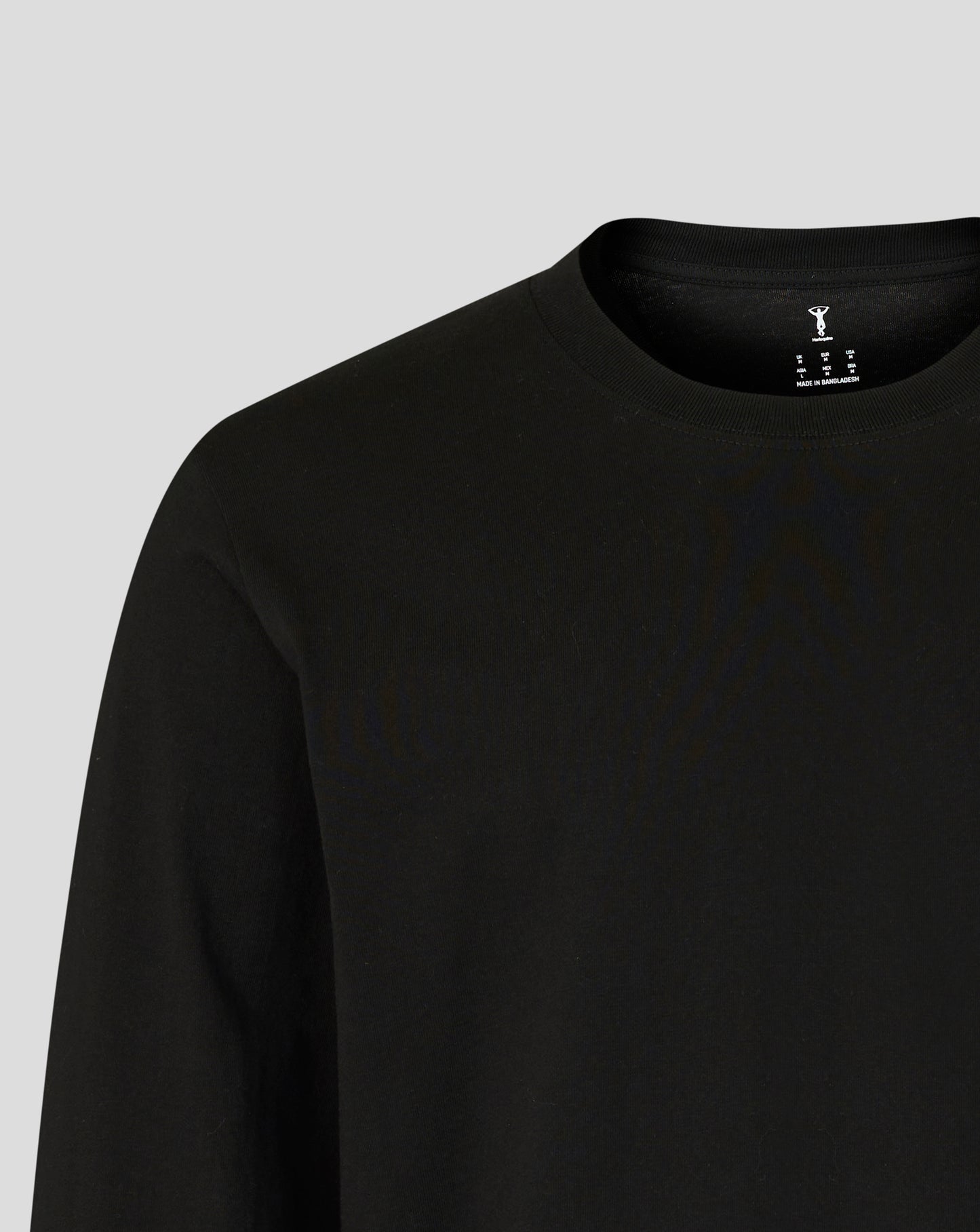 Close up of neckline showing Harlequins logo and size information printed inside the collar on the black long sleeve shirt.