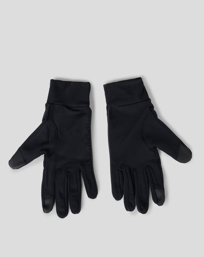 Pair of black gloves with textured palms laid on a light gray background
