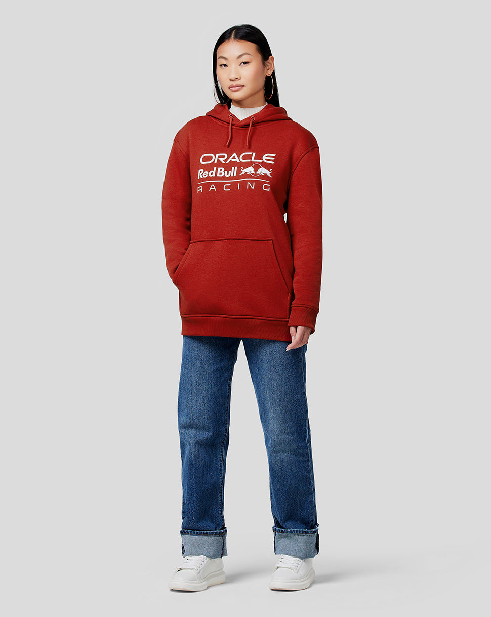 Front view of model wearing Winery red Oracle Red Bull Racing unisex core overhead hoodie with white chest logo.