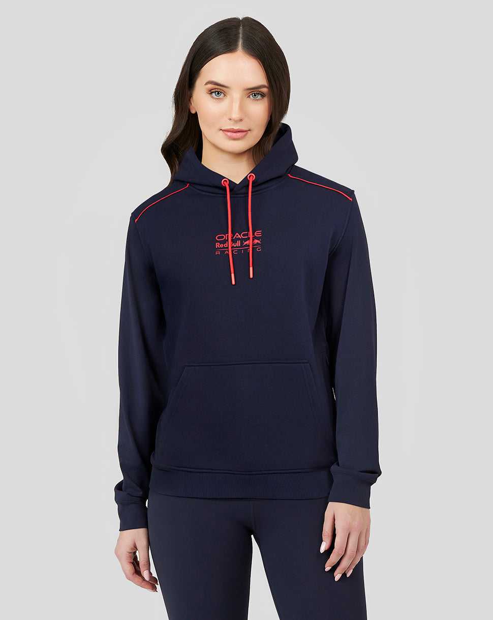 Female model in navy wrap-over hooded sweatshirt with red drawstrings and front logo