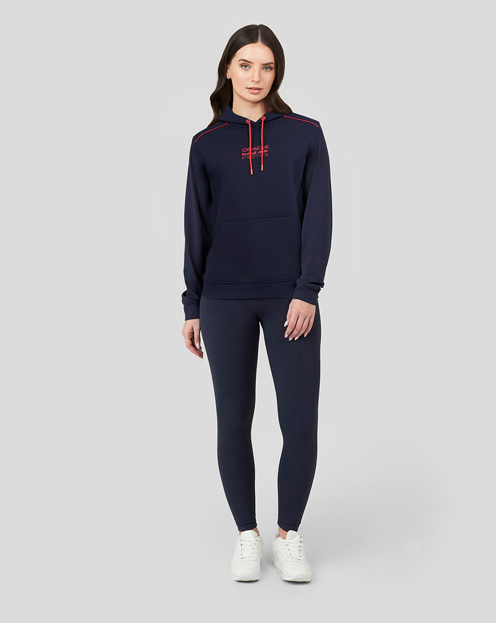 Full body front view of a woman in navy Red Bull hoodie with red drawcords and matching joggers