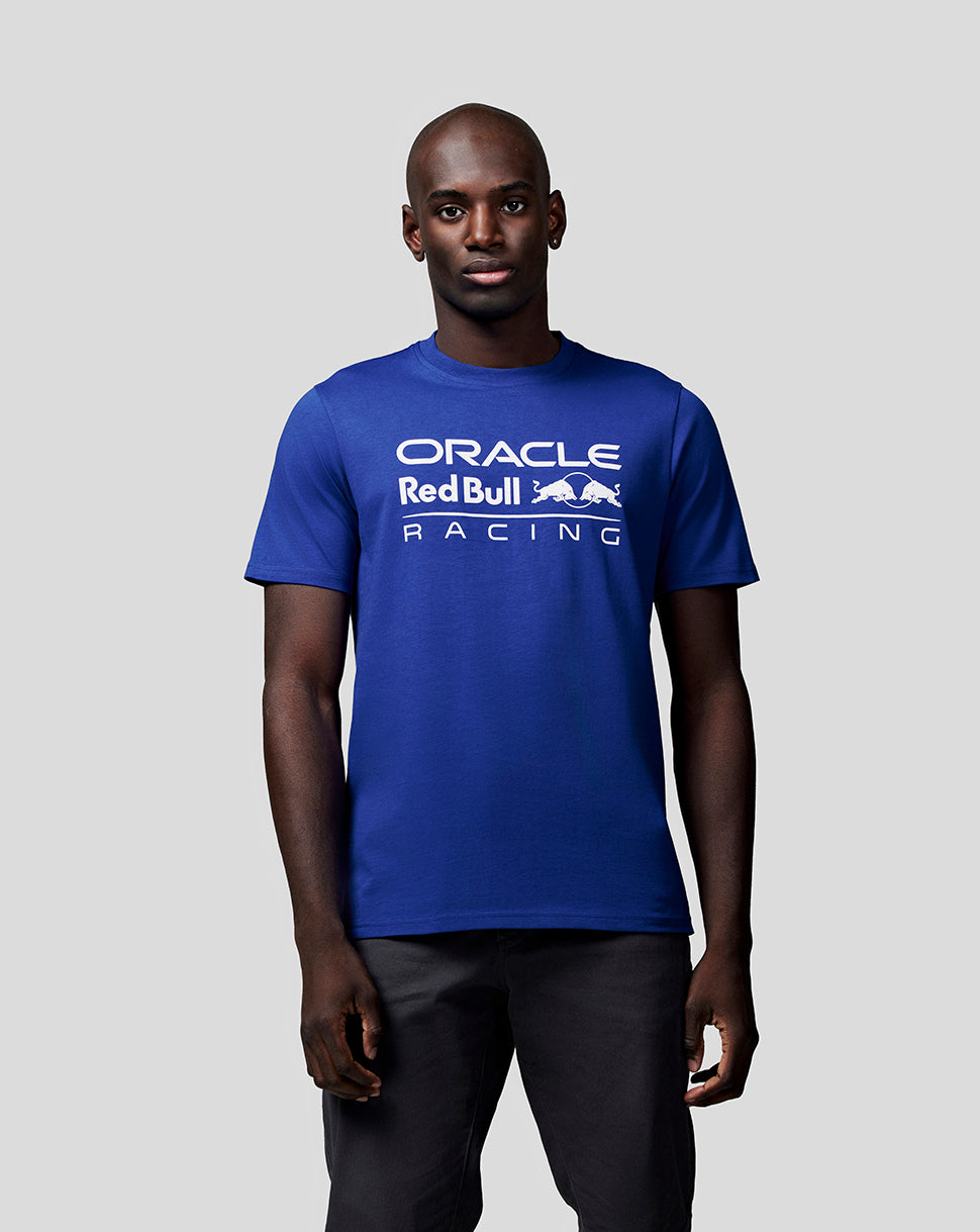 Full body shot of a model in a royal blue Oracle Red Bull Racing T shirt featuring a bold white logo on the chest