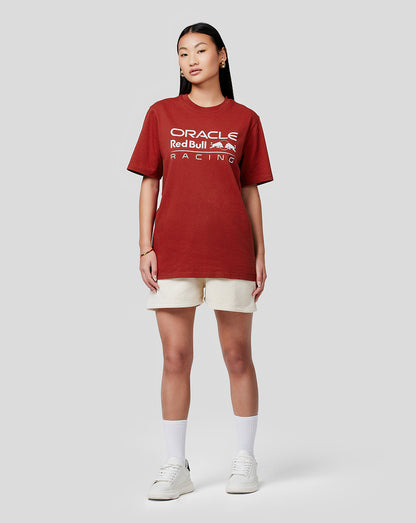 Woman wearing Oracle Red Bull Racing Winery red tee with beige shorts and white sneakers