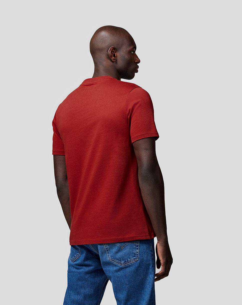 Side profile of a man wearing winery red Oracle Red Bull Racing T shirt with short sleeves and blue jeans