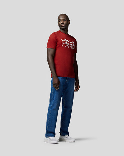 Man wearing winery red Oracle Red Bull Racing T shirt with white front logo, paired with blue jeans and white sneakers