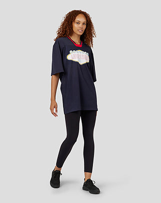Female model wearing navy Oracle Red Bull Racing Vegas American Football Jersey with Las Vegas sign graphic and black leggings.