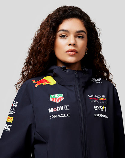 Woman wearing navy Oracle Red Bull Racing water resistant jacket with sponsor logos on the front