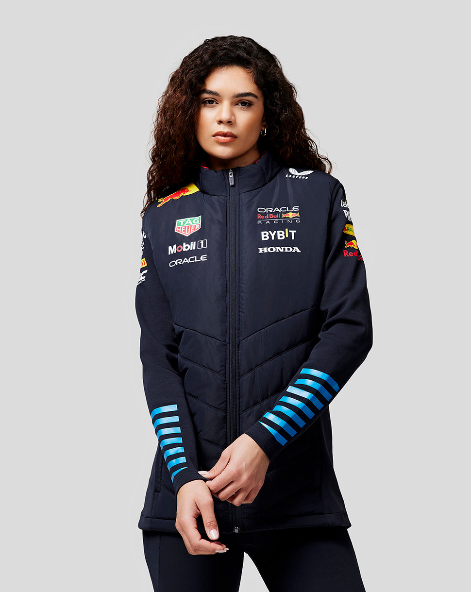 Front view of a woman wearing navy night sky Oracle Red Bull Racing teamline gilet with zipped front and sponsor logos on the chest and sleeves.