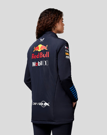 Side profile of a model in a navy Night Sky Oracle Red Bull Racing Hybrid Gilet with back branding and sleeve logos.