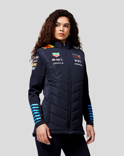Woman modeling navy night sky teamline hybrid gilet with quilted panels and chest logos.