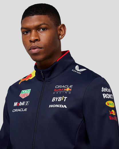 Front view of a navy Oracle Red Bull Racing jacket on a male model with multiple sponsor logos across the chest and sleeve