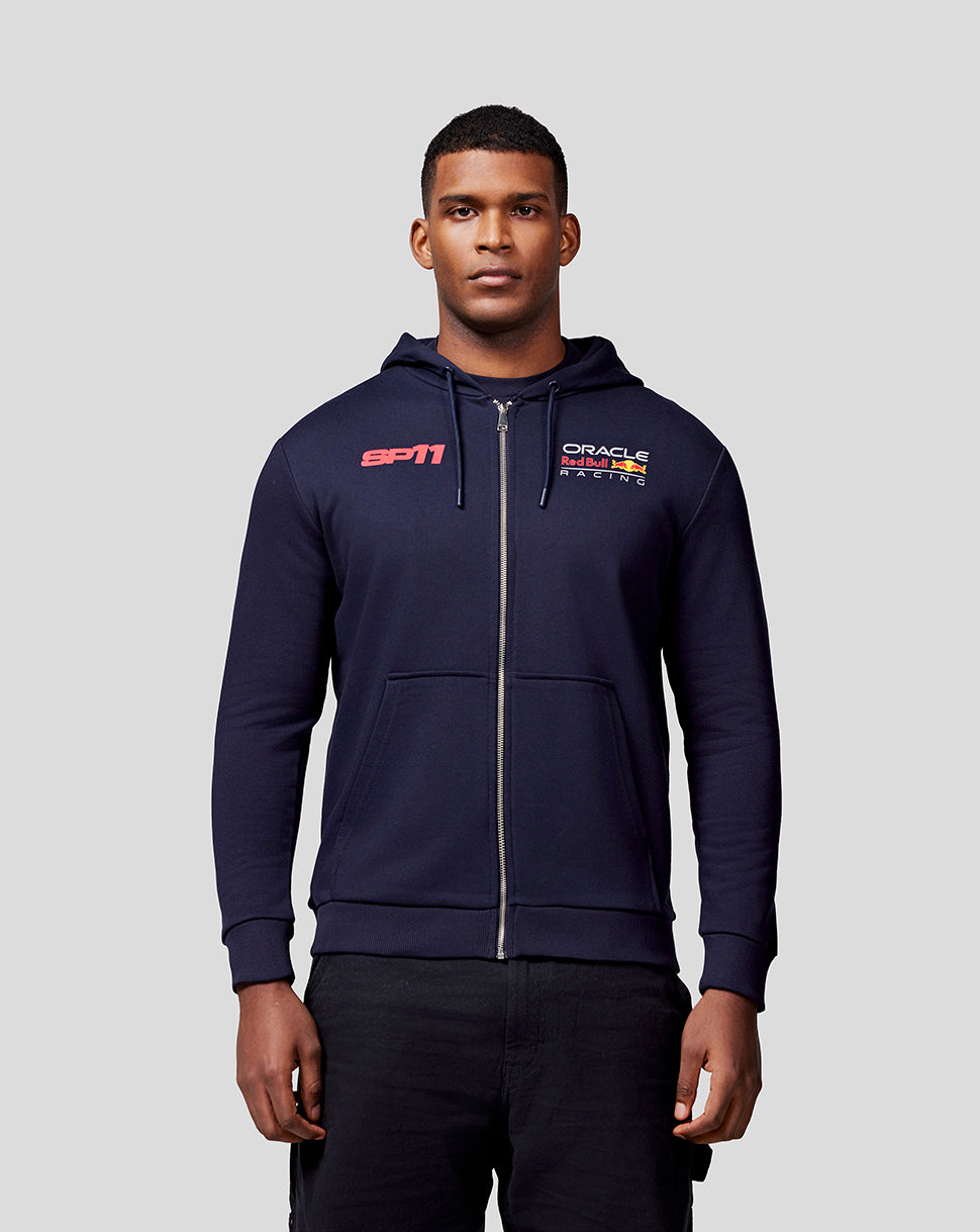 Front view of a man in a navy Checo Race Car zip hoodie with SP11 on the chest and Oracle Red Bull Racing branding