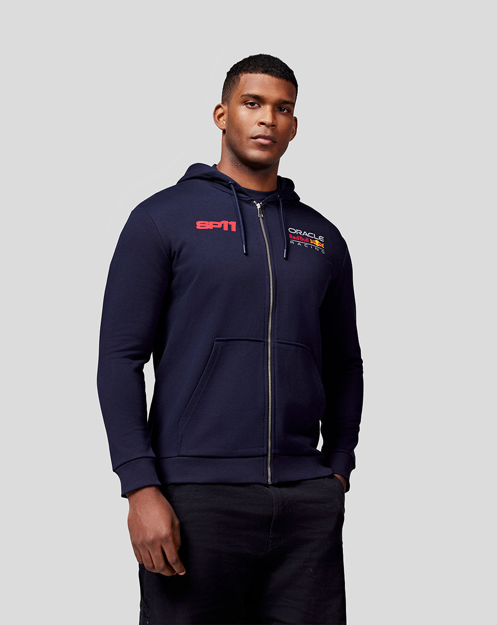 Front view of a model in the navy Checo Race Car Zip Hoodie featuring the SP11 graphic on the chest and Oracle Red Bull Racing branding