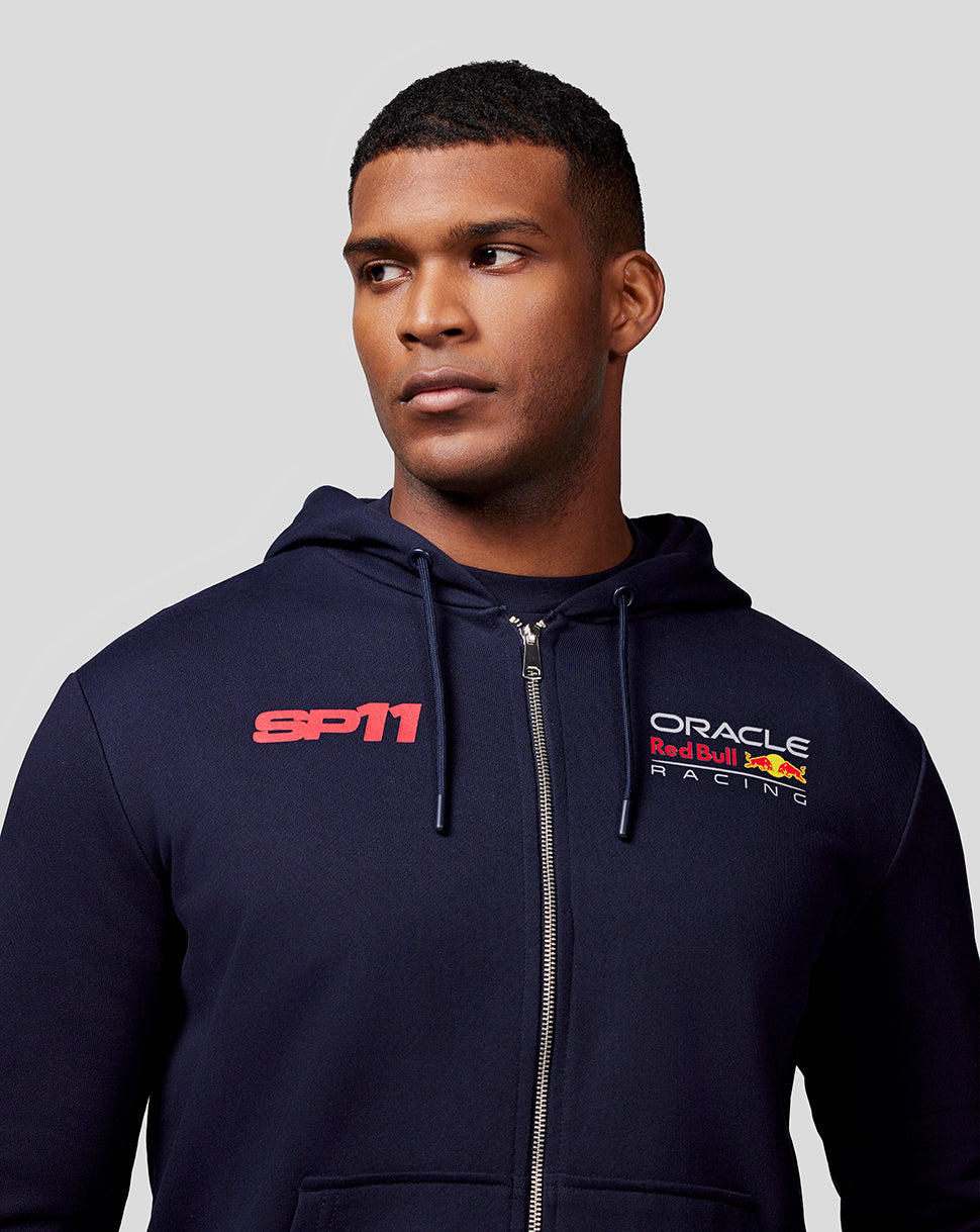 Male model in navy Checo Race Car Zip Hoodie with SP11 and Oracle Red Bull Racing logos on the chest and a front full zip