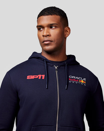 Male model in navy Checo Race Car Zip Hoodie with SP11 and Oracle Red Bull Racing logos on the chest and a front full zip