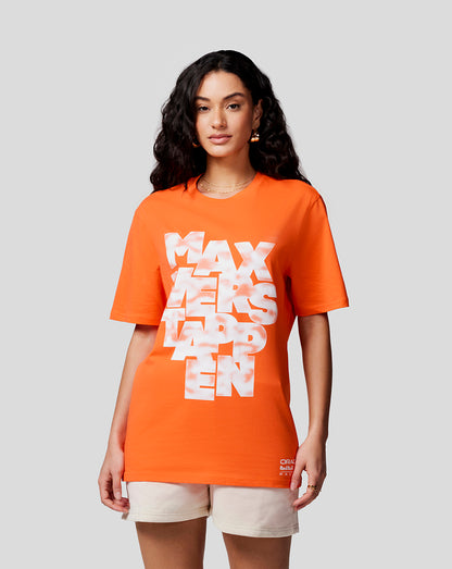 Front view of a woman wearing a bright orange Max Expression Tee with a bold white graphic on the chest.