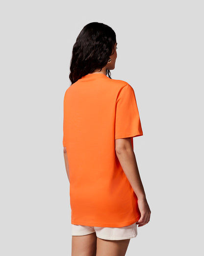 Back view of a woman in a bright orange Max Expression Tee.
