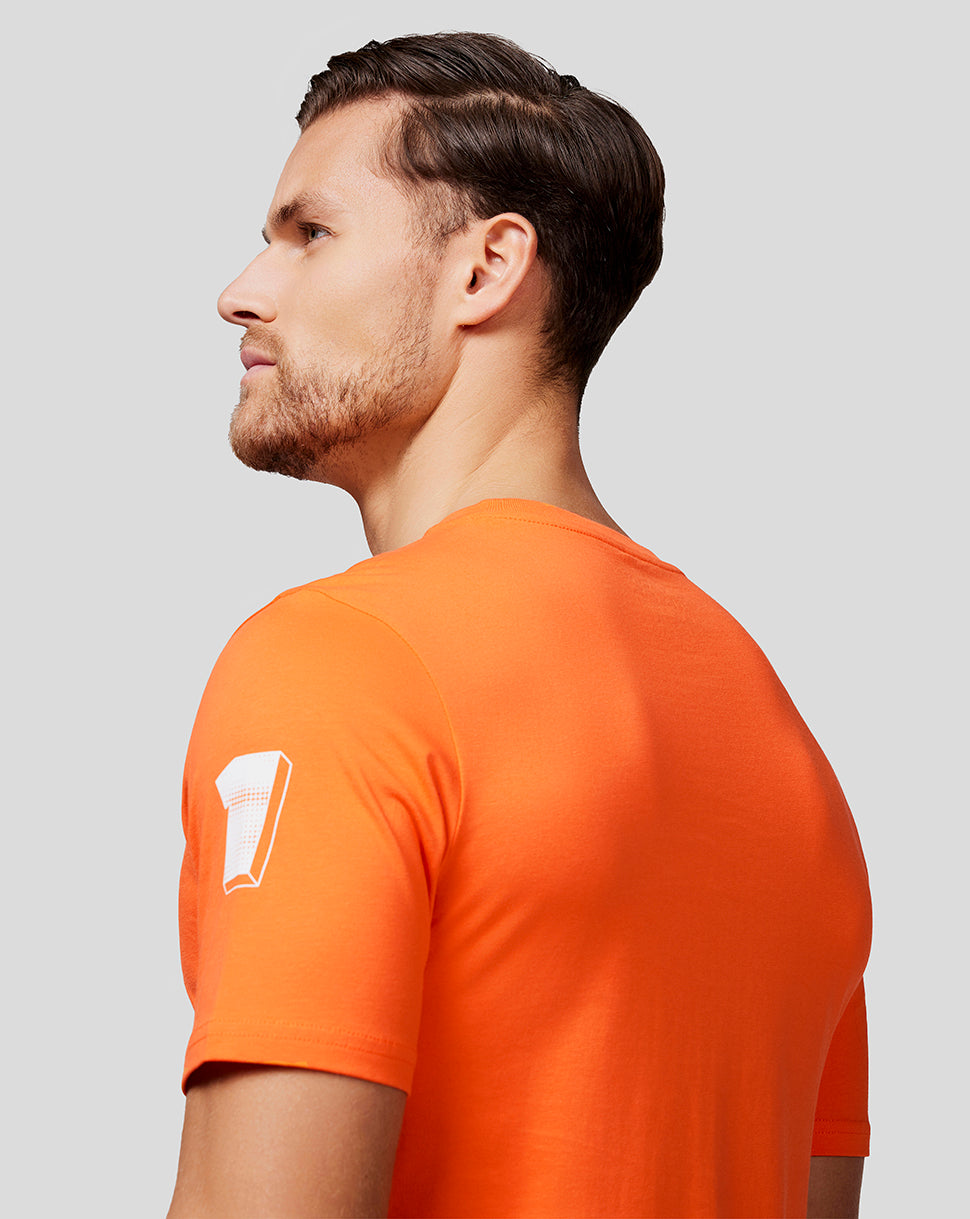 Side view of a man wearing a bright orange Max Expression T shirt with a white graphic on the sleeve.