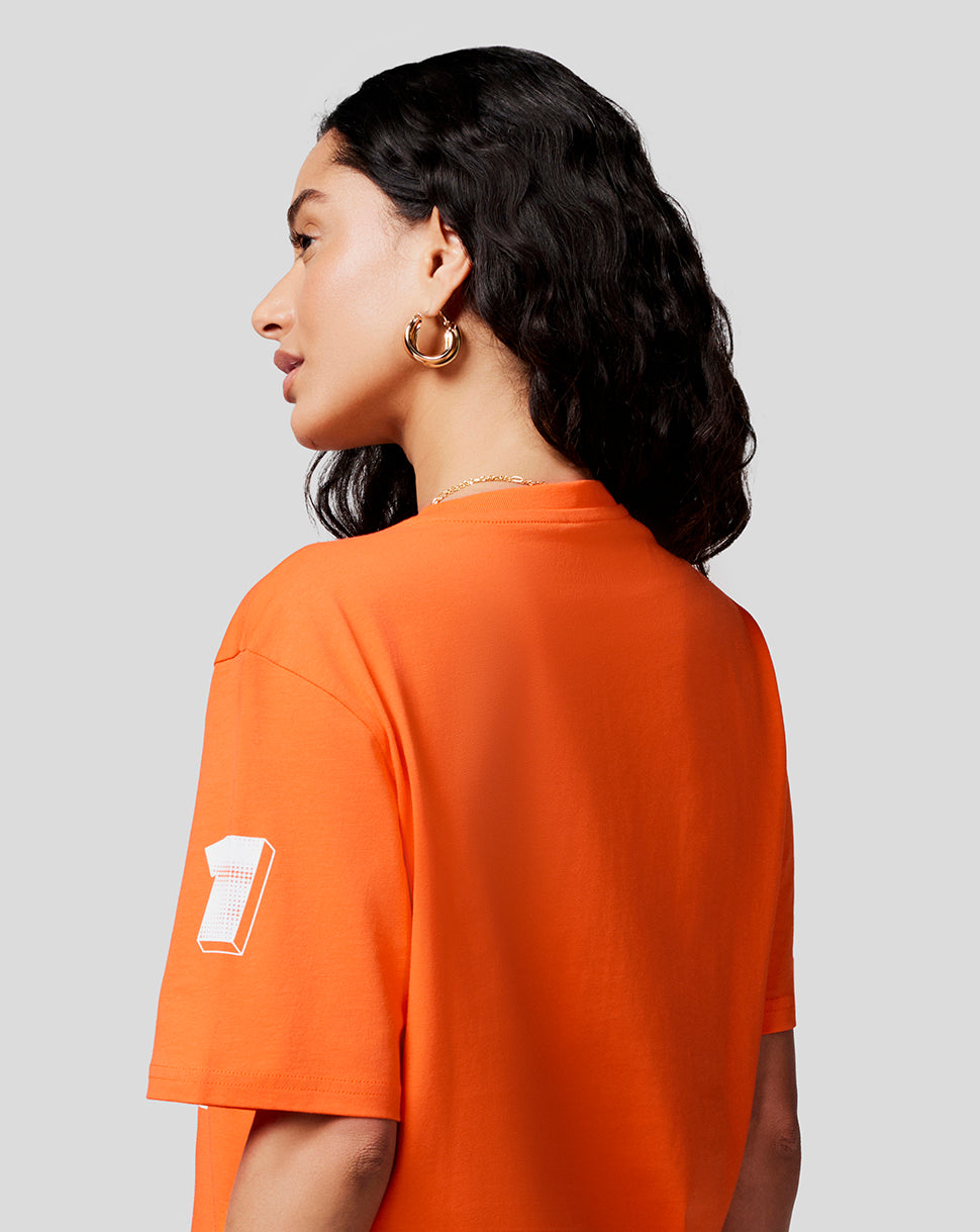 Side view of a model in Exotic Orange Max Expression Tee showing a white number 1 graphic on the left sleeve.