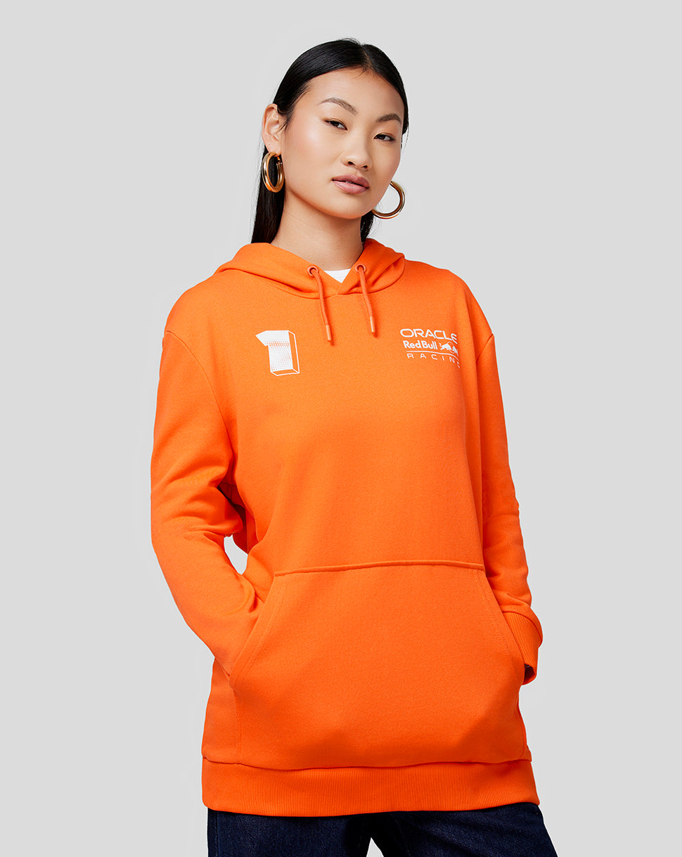 Woman in bright orange hoodie with front kangaroo pocket and white branding on the chest