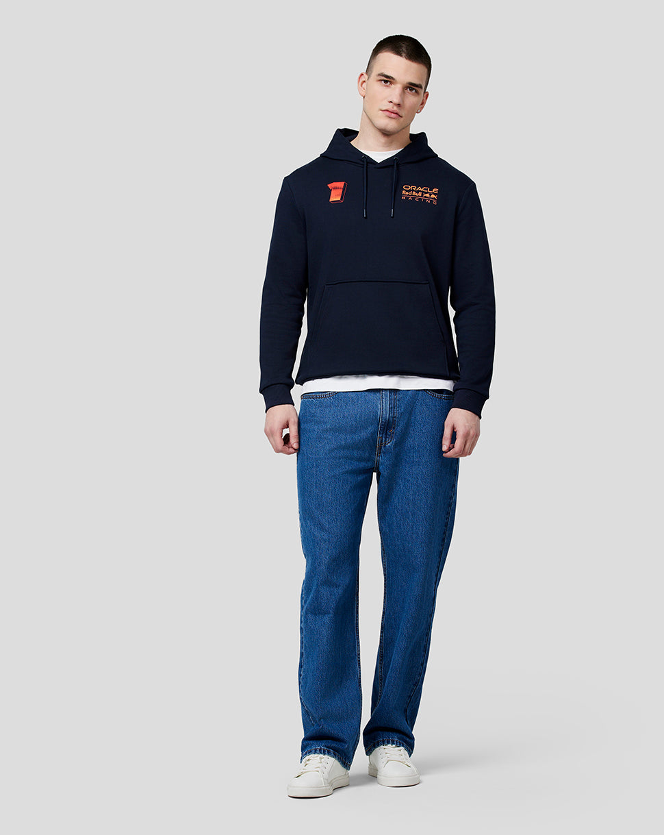 Full-body view of a male model in a navy Max Expression Hoodie with chest logos and a kangaroo pocket.