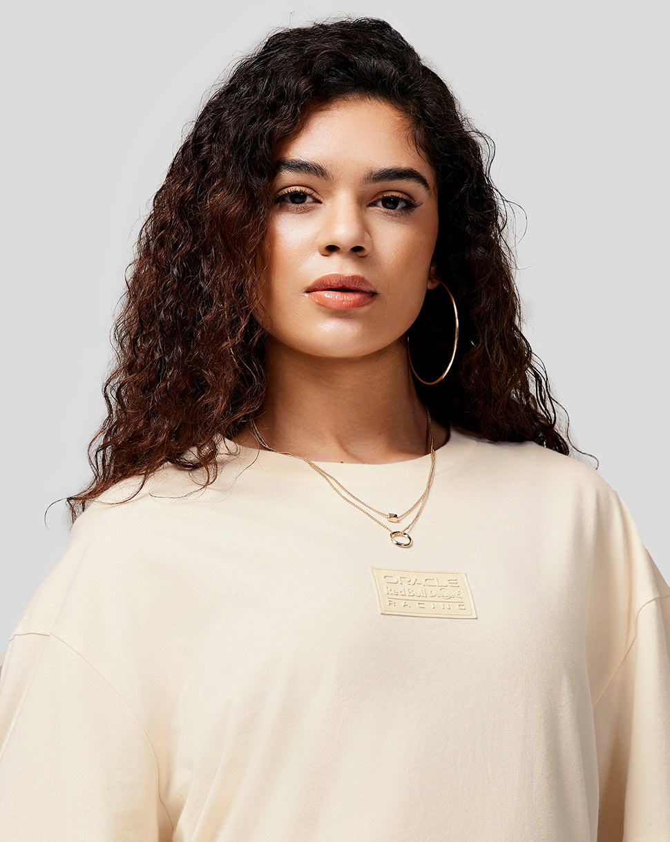 Beige oversized crewneck T shirt with RBR patch on chest worn by a woman