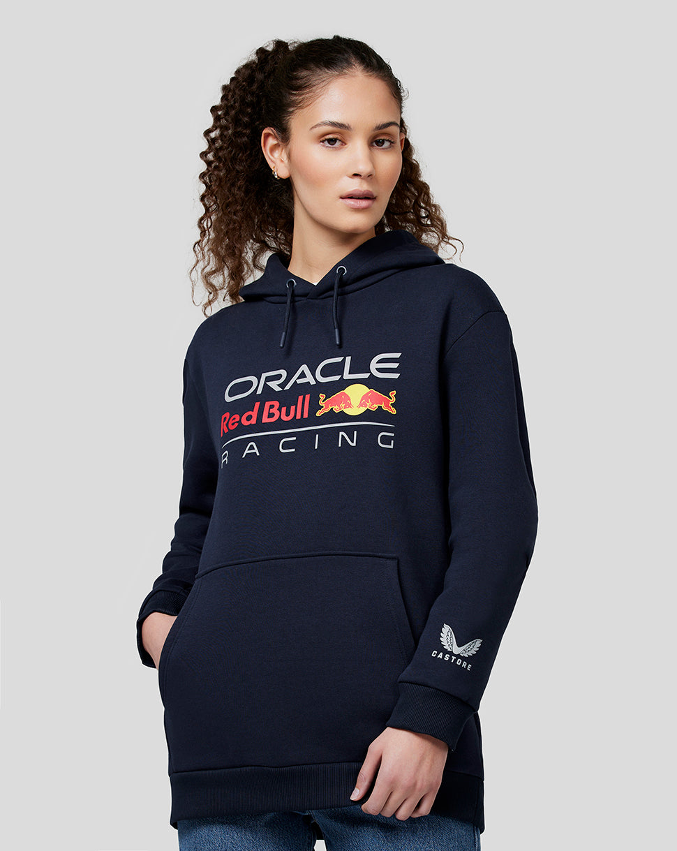 Woman wearing navy hoodie with Oracle Red Bull Racing graphic on the chest and Castore logo on the sleeve.