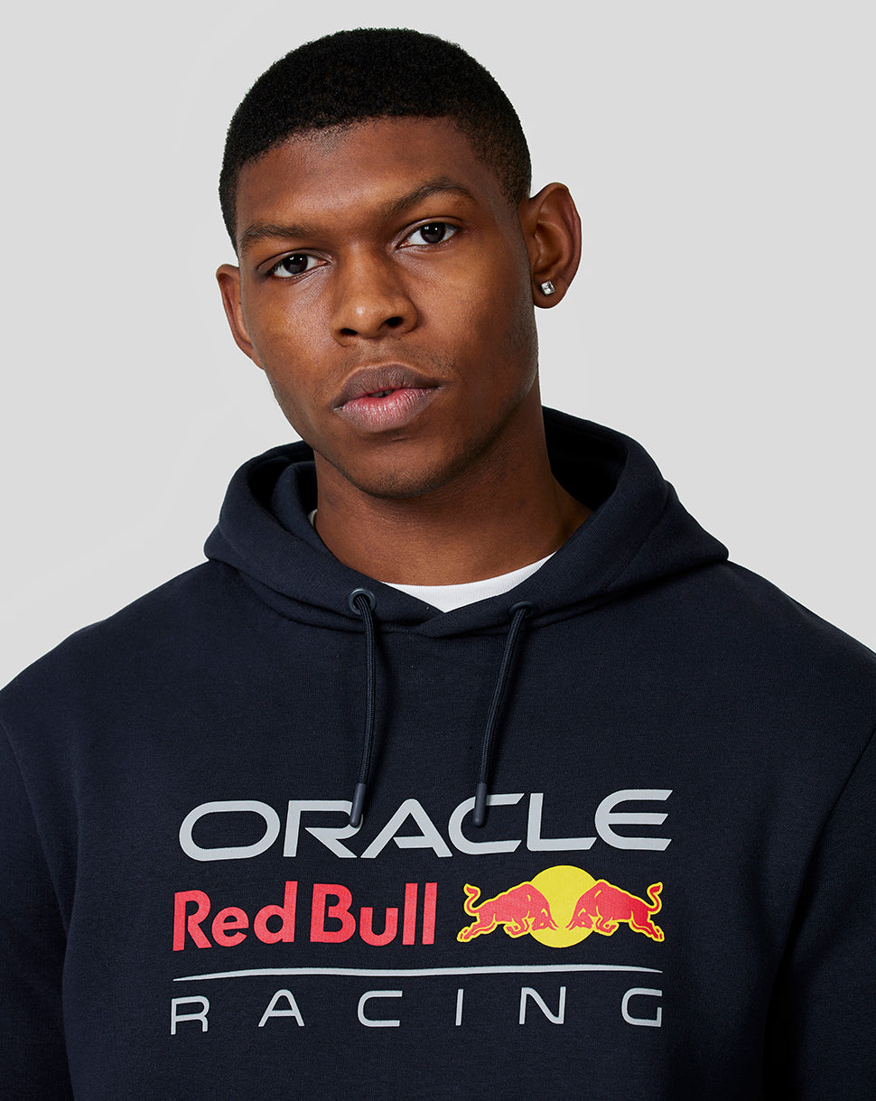 Model wearing navy Oracle Red Bull Racing hoodie with chest logo and drawstring hood.