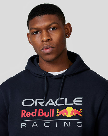 Model wearing navy Oracle Red Bull Racing hoodie with chest logo and drawstring hood.