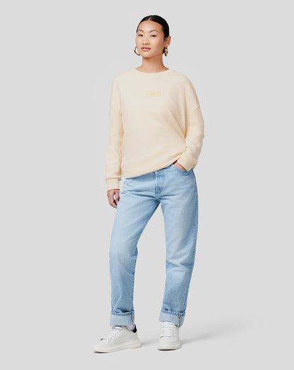 Model wearing Oracle Red Bull Racing unisex tonal oversized crew neck sweatshirt in ecru with an RBR patch on chest