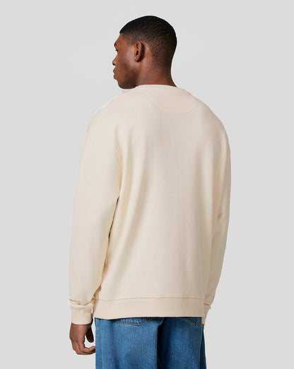 Back view of a model in the ecru oversized crew neck sweatshirt showing the relaxed loose fit.