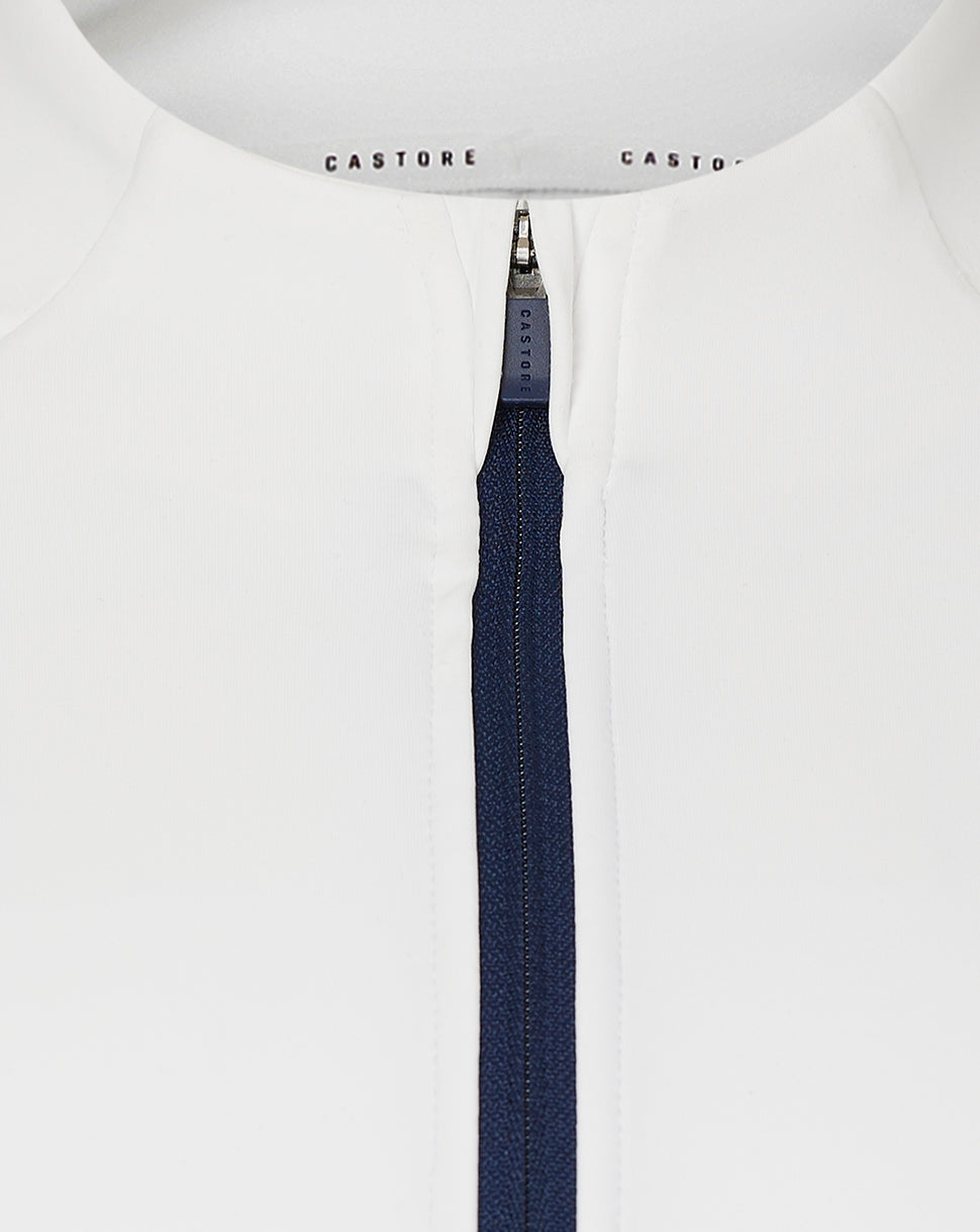 Close up of white quarter zip neck with navy zipper and Castore branding on collar tape.