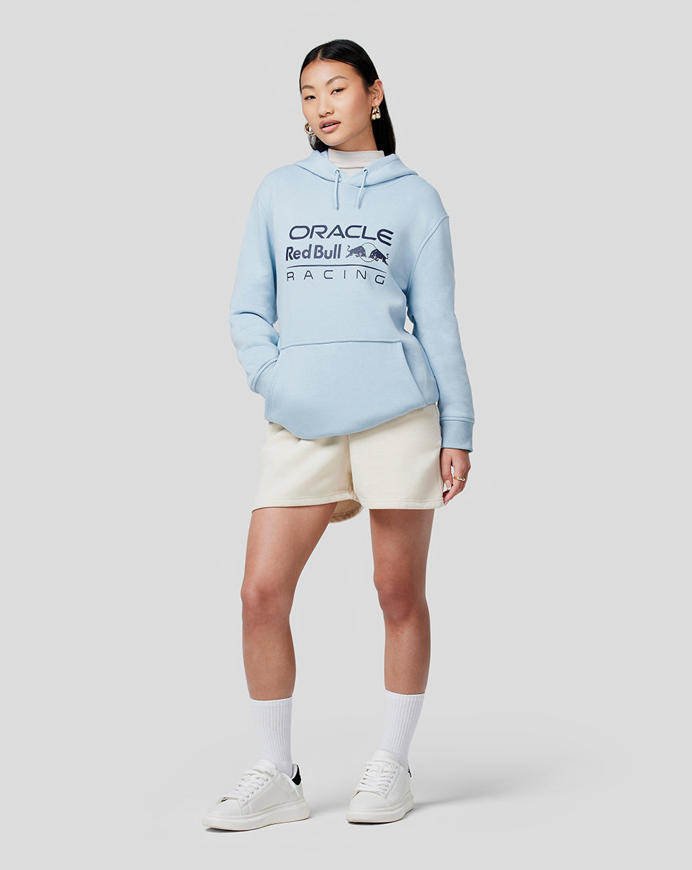 Female model in Dream Blue Oracle Red Bull Racing hoodie with front chest logo and kangaroo pocket.