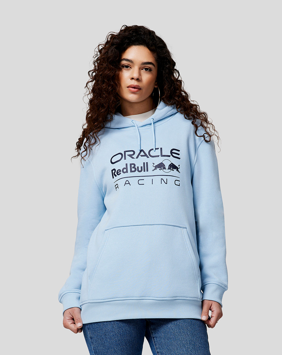 Front view of a woman wearing a Dream Blue Oracle Red Bull Racing hoodie with logo on the chest and front pocket