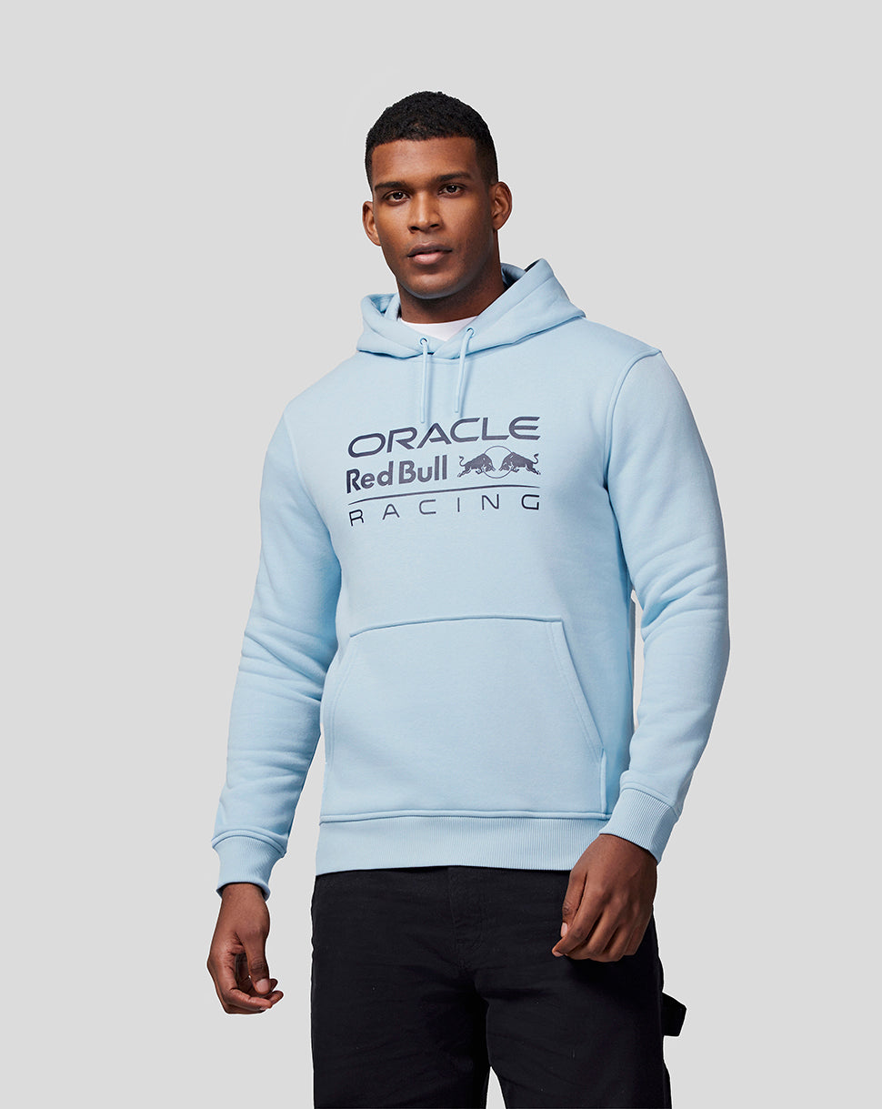 Full body view of a model in a Dream Blue Oracle Red Bull Racing hoodie with chest logo and black pants.