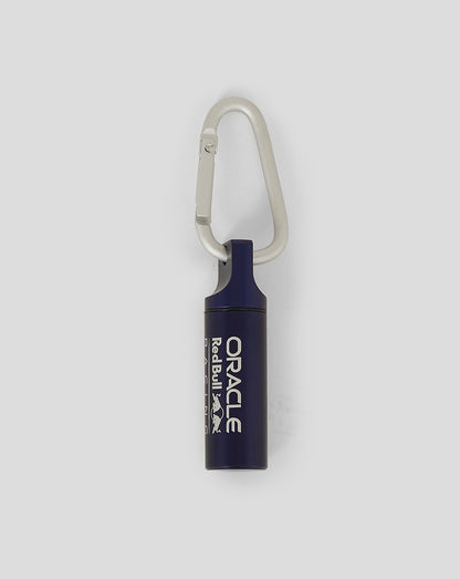 Close-up of Oracle Red Bull Racing ear plug canister keyring in night sky with white branding and carabiner