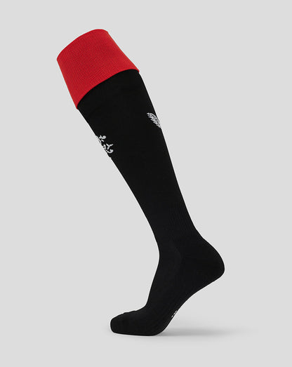 Full view of junior Rangers home sock on leg, black body with red foldover cuff and white crest on shin.