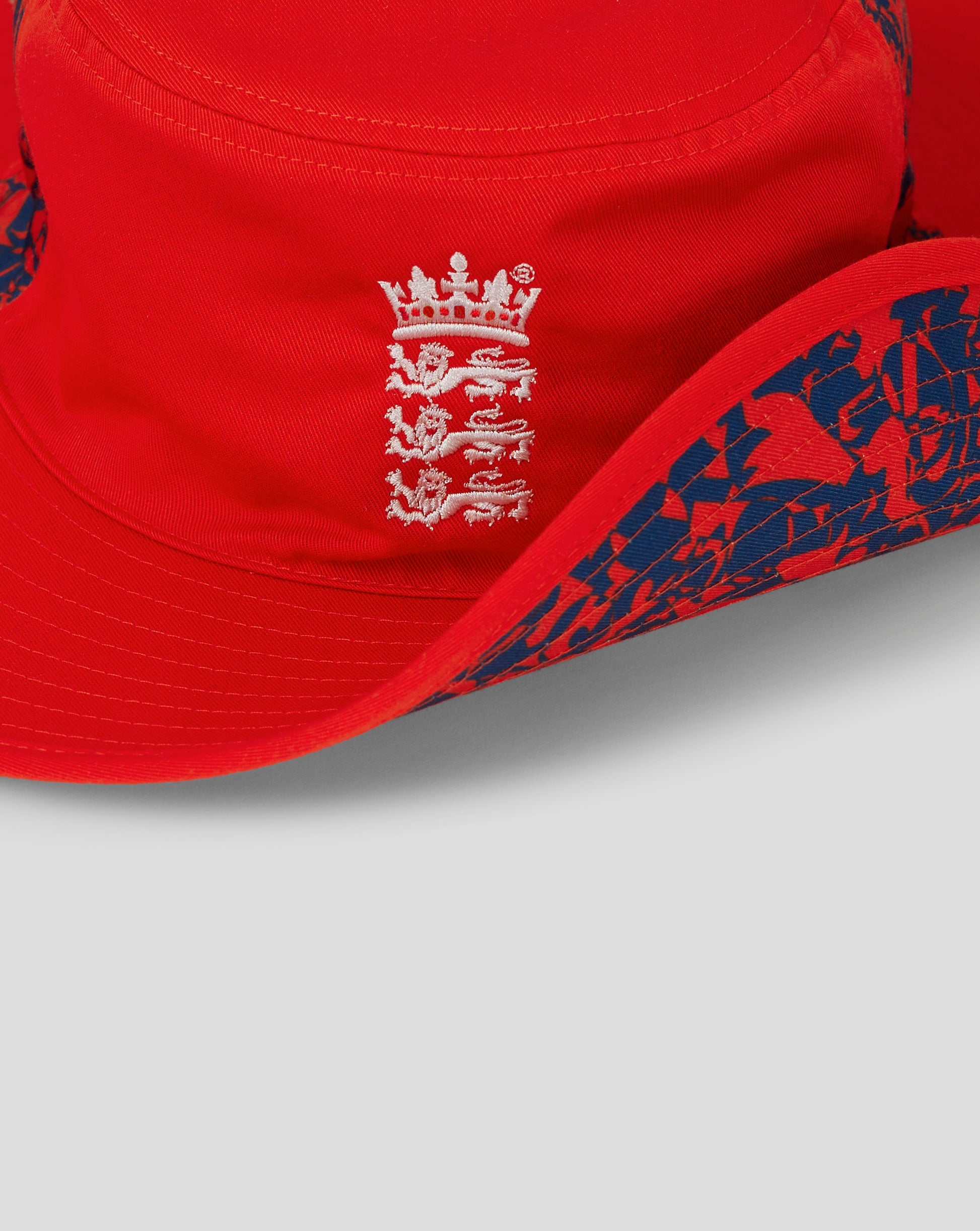 Side view of fiery red England cricket wide brim hat with blue patterned brim and Castore branding on the reverse