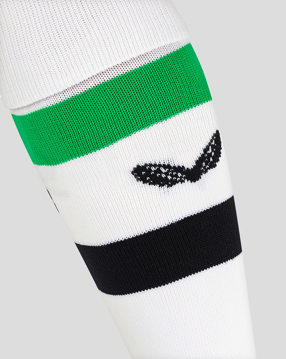 Close up of Mansfield away sock showing a green stripe and a black club crest on white knit.
