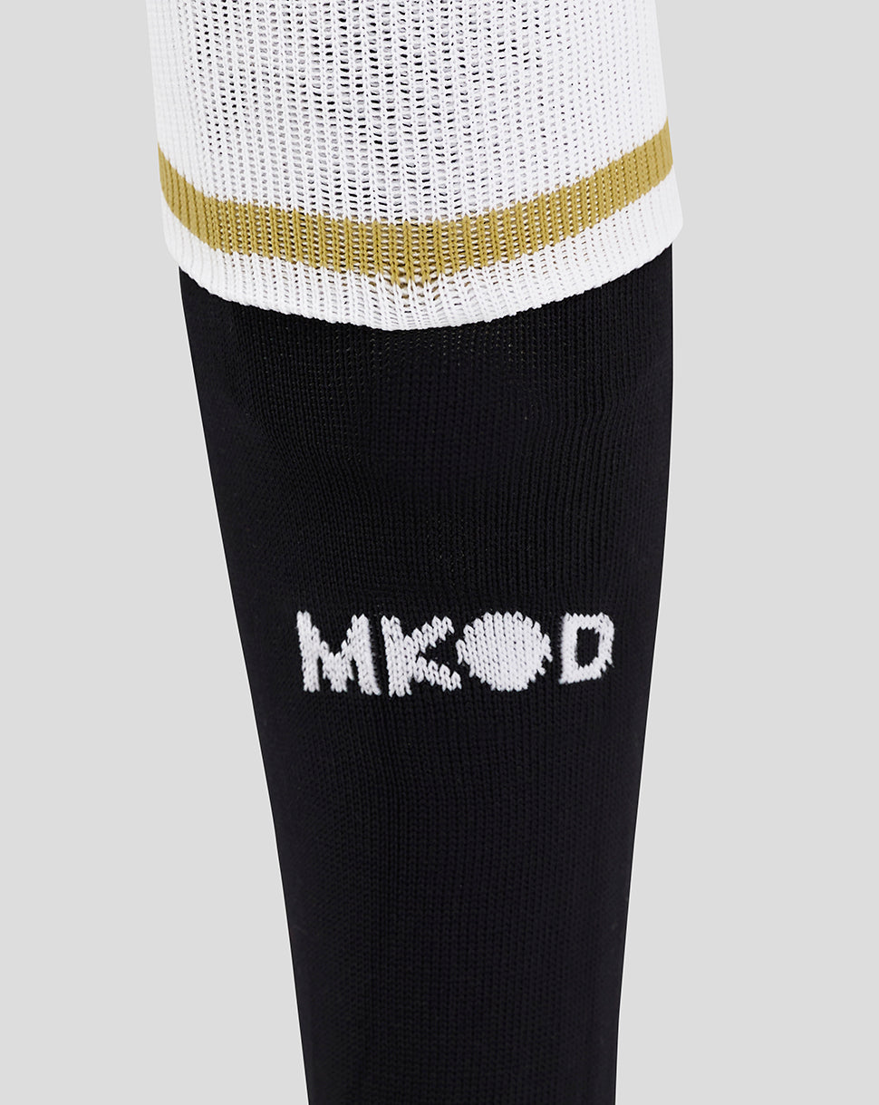 Close-up of Mk Dons Unisex 24/25 Third Socks showing white knit cuff with a gold stripe and black leg with white Mk Dons logo