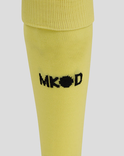Close-up of the yellow Mk Dons goalkeeper sock with a black embroidered logo on the calf.
